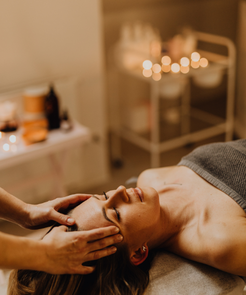 A woman getting a facial massage at a spa